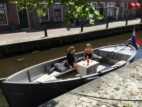 two women sitting in a boat in the water at b&b het Herenhuys aan de historische gracht van Kollum in Kollum