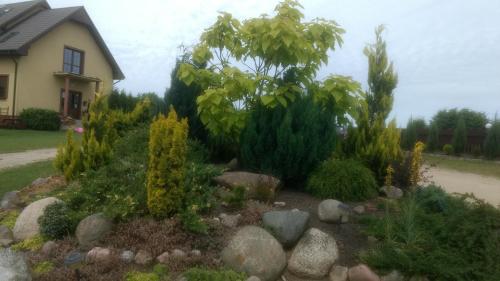 a garden with rocks and plants in front of a house at Dom Wczasowy Pięciu Pomostów in Czaplinek