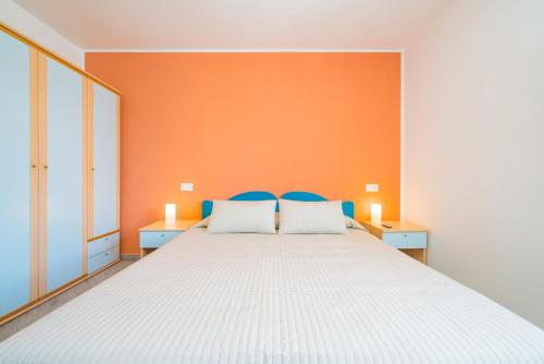 a bedroom with a large bed with an orange wall at Hotel Ristorante Crescenzo in Procida