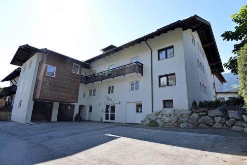 a large white building with a stone wall at Appartements Pungg in Fügen
