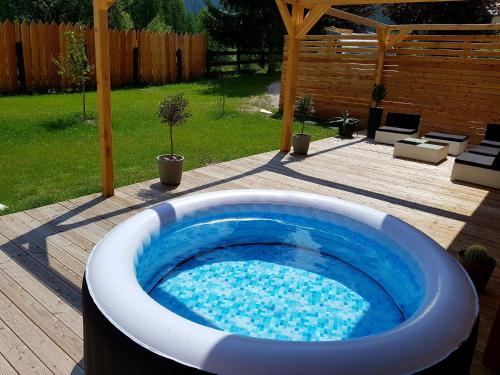 a large hot tub in a yard with a patio at Aqua Apartments Spa Housemuhlbach in Sappada