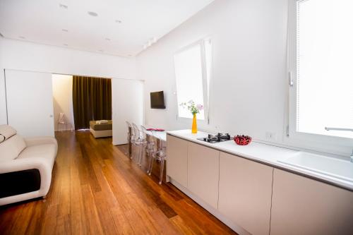 eine Küche und ein Wohnzimmer mit Sofa und Tisch in der Unterkunft Cefalù Charme e Chic Suites in Cefalú