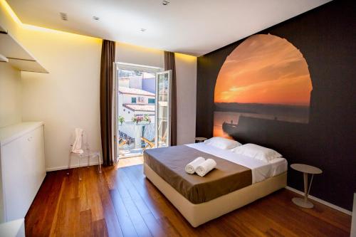 ein Schlafzimmer mit einem Bett und einem großen Fenster in der Unterkunft Cefalù Charme e Chic Suites in Cefalú