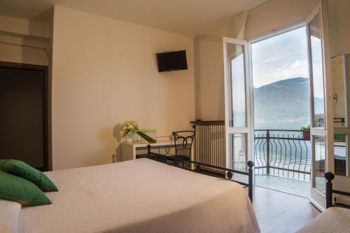 a bedroom with a bed and a balcony with a view at Crotto dei Pescatori in Lezzeno