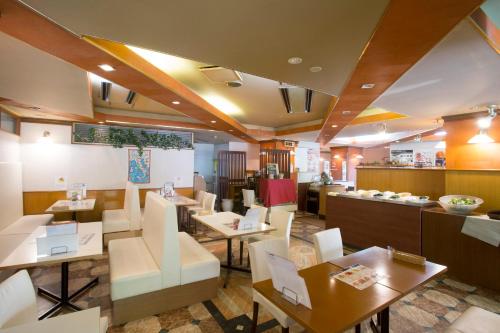 un restaurant avec des tables, des chaises et un comptoir dans l'établissement Tetoranze Makuhari Inagekaigan Hotel, à Chiba