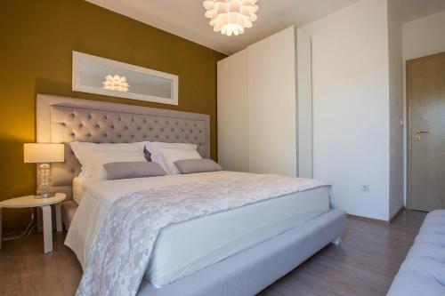 a bedroom with a large bed and a chandelier at Apartment Toni Relax in Split