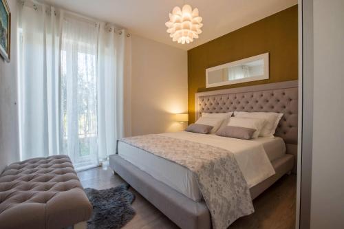 a bedroom with a large bed and a chandelier at Apartment Toni Relax in Split