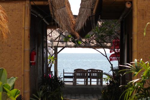 a view of the ocean from a building with chairs at Beachouse Lovina in Lovina