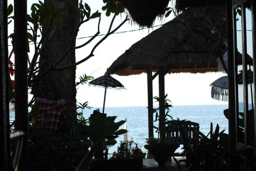 a view of the ocean from a patio with umbrellas at Beachouse Lovina in Lovina