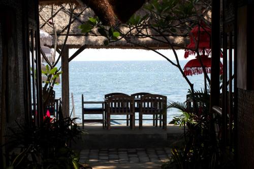a view of the ocean from a room with two chairs at Beachouse Lovina in Lovina