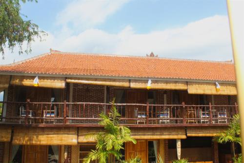 a building with a deck with people on it at Beachouse Lovina in Lovina