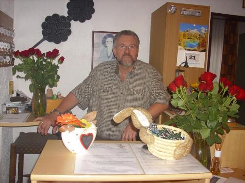 a man sitting at a table with a vase at Hotel Europa in Holsthum
