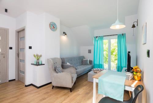een woonkamer met een blauwe bank en een tafel bij Apartament Zeglarski in Powidz