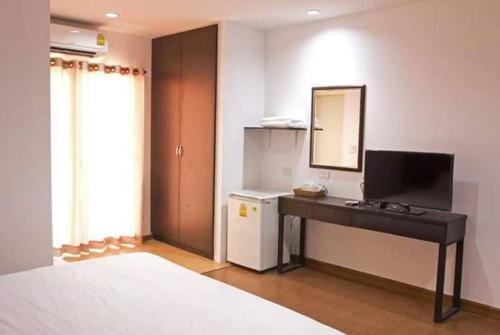 1 dormitorio con escritorio, espejo y lavamanos en Field Town Apartment, en Nakhon Nayok