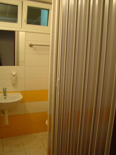 a bathroom with a sink and a shower curtain at Penzion Cabák in Vrchlabí