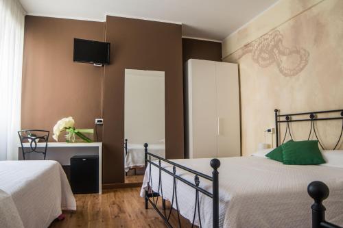 a bedroom with two beds and a tv on the wall at Crotto dei Pescatori in Lezzeno