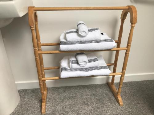 a bamboo towel rack with white towels on it at Daedalus Bed & Breakfast in Muir of Ord