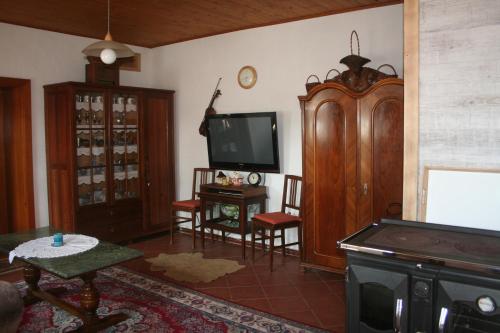 a living room with a flat screen tv and a table at Chalupa u studny in Lukov