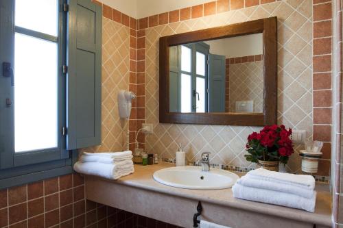 a bathroom with a sink and a mirror at Hotel Bia Maore in Baunei