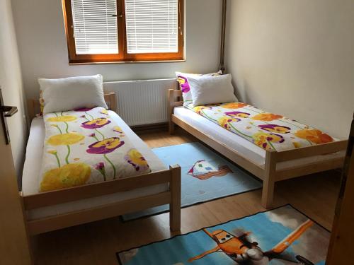 a bedroom with two beds and a rug at Apartment near the Airport in Sarajevo
