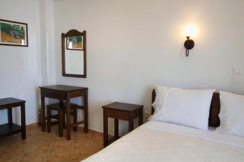 a bedroom with a bed with two tables and a mirror at Kimite in Armenistis