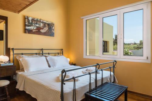 1 dormitorio con 1 cama y 2 ventanas en Daphnis Villas, en Máleme