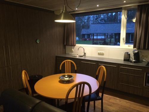 a table and chairs in a kitchen with a table and a window at Vosseven 32 Geelgors in Stramproy