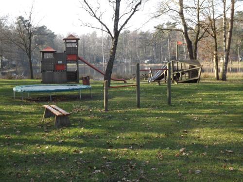 a park with two playground equipment in the grass at Vosseven 32 Geelgors in Stramproy