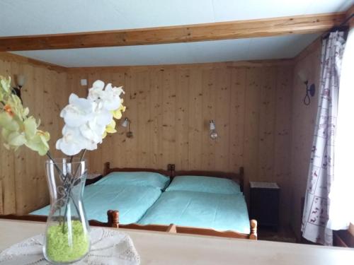 a bedroom with a bed and a vase of flowers on a table at Hôtel du Chamois in L'Etivaz