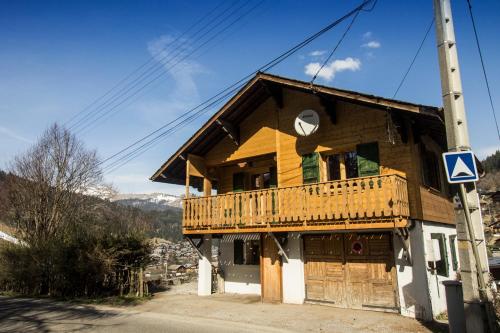 une maison en bois avec un balcon dans une rue dans l'établissement Chalet Mimi, à Morzine