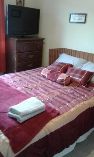 ein Bett mit zwei gefalteten Handtüchern und einem TV in der Unterkunft Cozy pet friendly Home in St. John's
