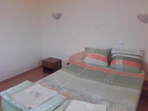 a bedroom with a bed with towels on it at Hotel Aleksievata Kashta in Gurgulyat
