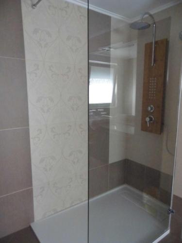 a shower with a glass door in a bathroom at B&B Eva in Ičići