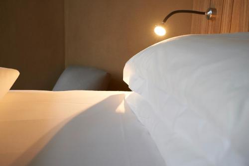a bedroom with a bed with a lamp and a chair at Alte Apotheke in Bad Essen