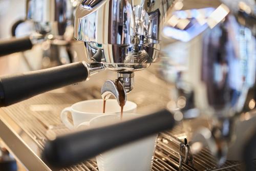 a coffee maker is making a cup of coffee at Alte Apotheke in Bad Essen