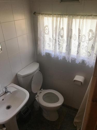 a bathroom with a white toilet and a sink at Merry Pebbles Resort in Sabie