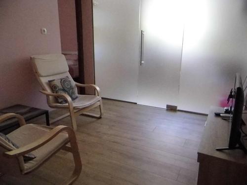 a living room with two chairs and a sliding door at B&B Eva in Ičići