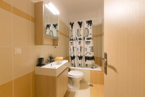 een badkamer met een toilet, een wastafel en een douchegordijn bij Velia Boutique Apartments in Ouranoupoli
