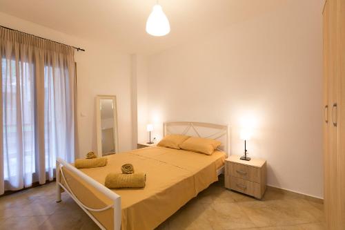een slaapkamer met een groot bed en een raam bij Velia Boutique Apartments in Ouranoupoli