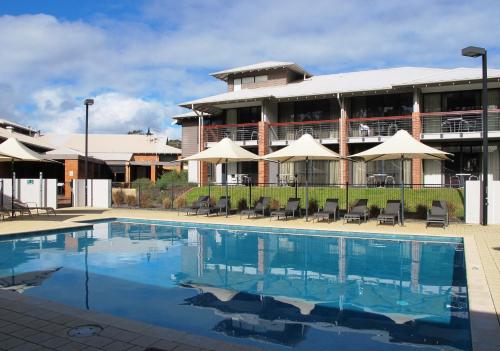 a swimming pool in front of a building at Margarets In Town Apartments in Margaret River Town