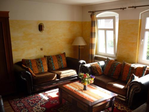 a living room with two couches and a coffee table at Alte Weberei in Straupitz