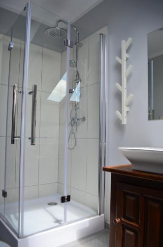 a glass shower in a bathroom with a sink at A Morze Ustka in Ustka