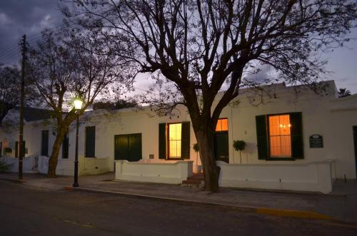 une maison blanche avec un arbre en face dans l'établissement De Kothuize 6, à Graaff-Reinet