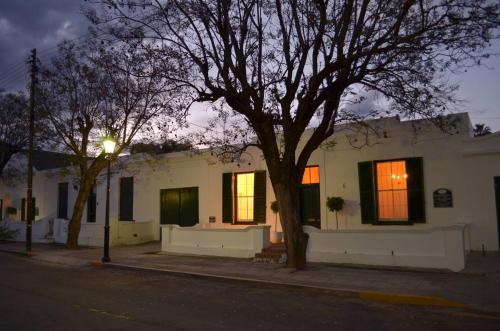 a white house with a tree in front of it at De Kothuize 6 in Graaff-Reinet