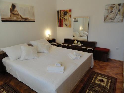 a bedroom with a large white bed with towels on it at Dada Apartment in Rijeka