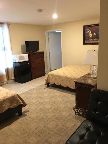 a hotel room with two beds and a television at Misquamicut Beach Front Inn in Misquamicut