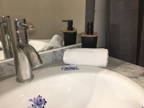 un lavabo de salle de bain avec une fleur bleue et blanche dessus dans l'établissement Bandol Port & Plage, à Bandol