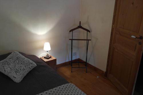 a bedroom with a bed and a lamp on a floor at La Grunonde in Palogneux