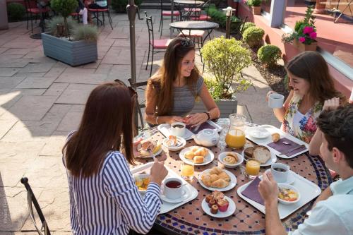 a group of people sitting around a table eating food at Logis Hôtel Atrium Epinal Golbey in Épinal
