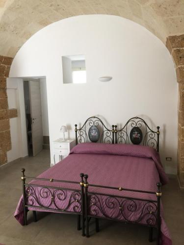 a bedroom with a bed with a purple blanket at Borgo Sofia Bed and Breakfast in Mesagne